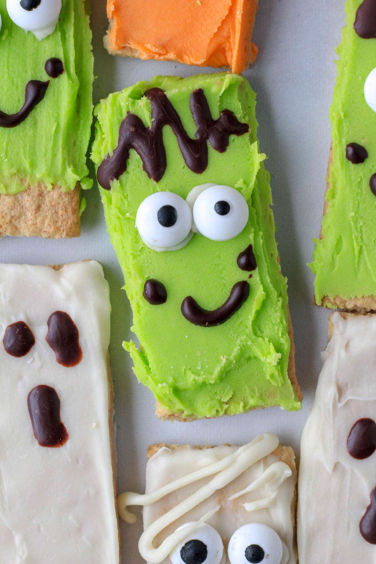 A monster decorated white chocolate dipped graham cracker for Halloween.