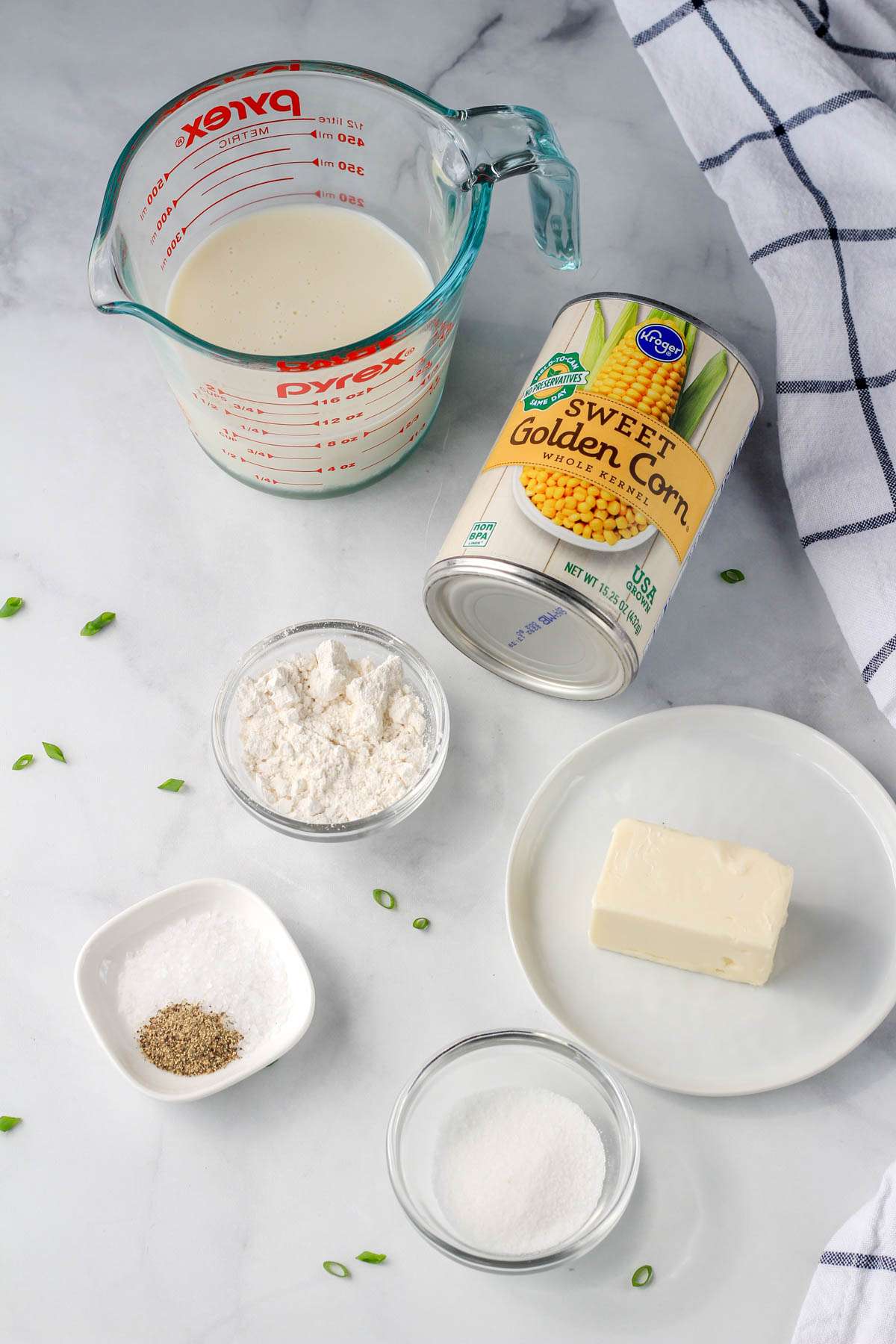 Ingredients for vegan creamed corn on a white counter.