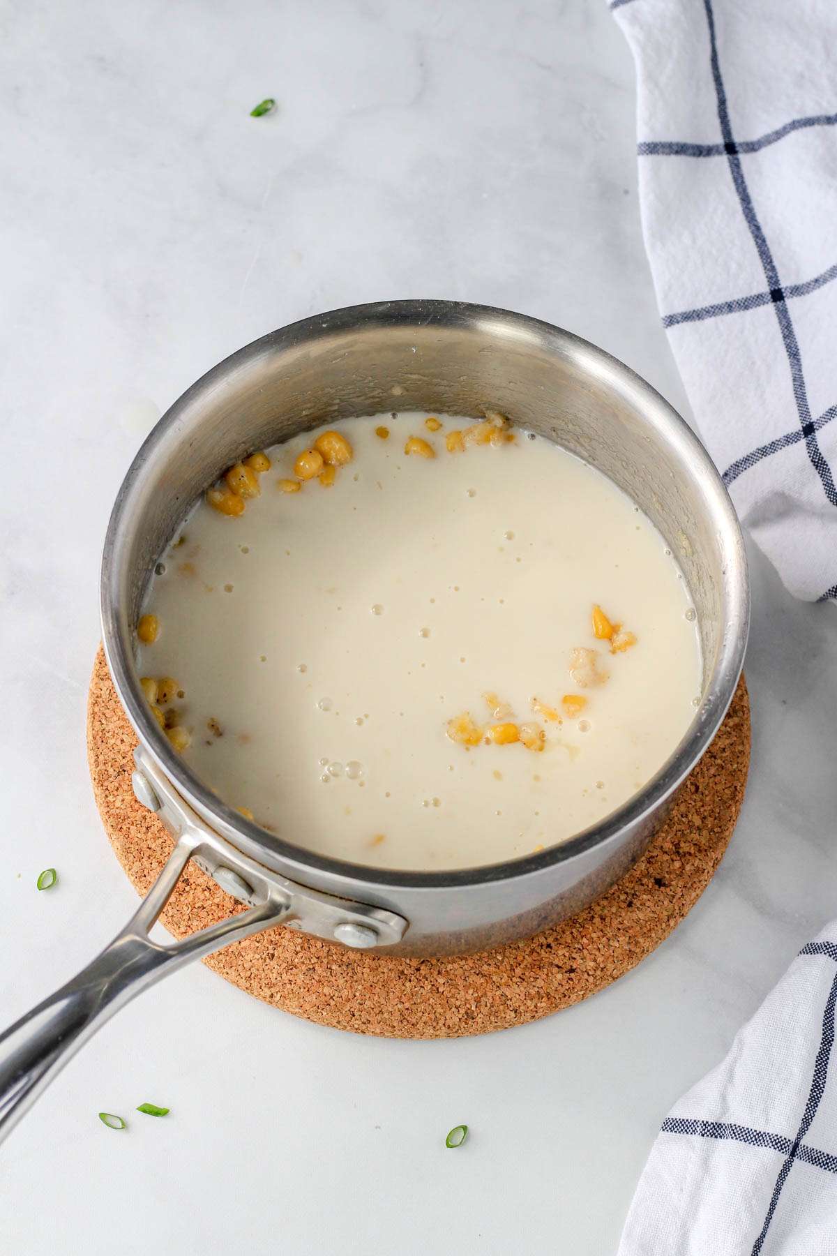 A sauce pan with creamed corn before reducing the dairy-free milk in the pan.