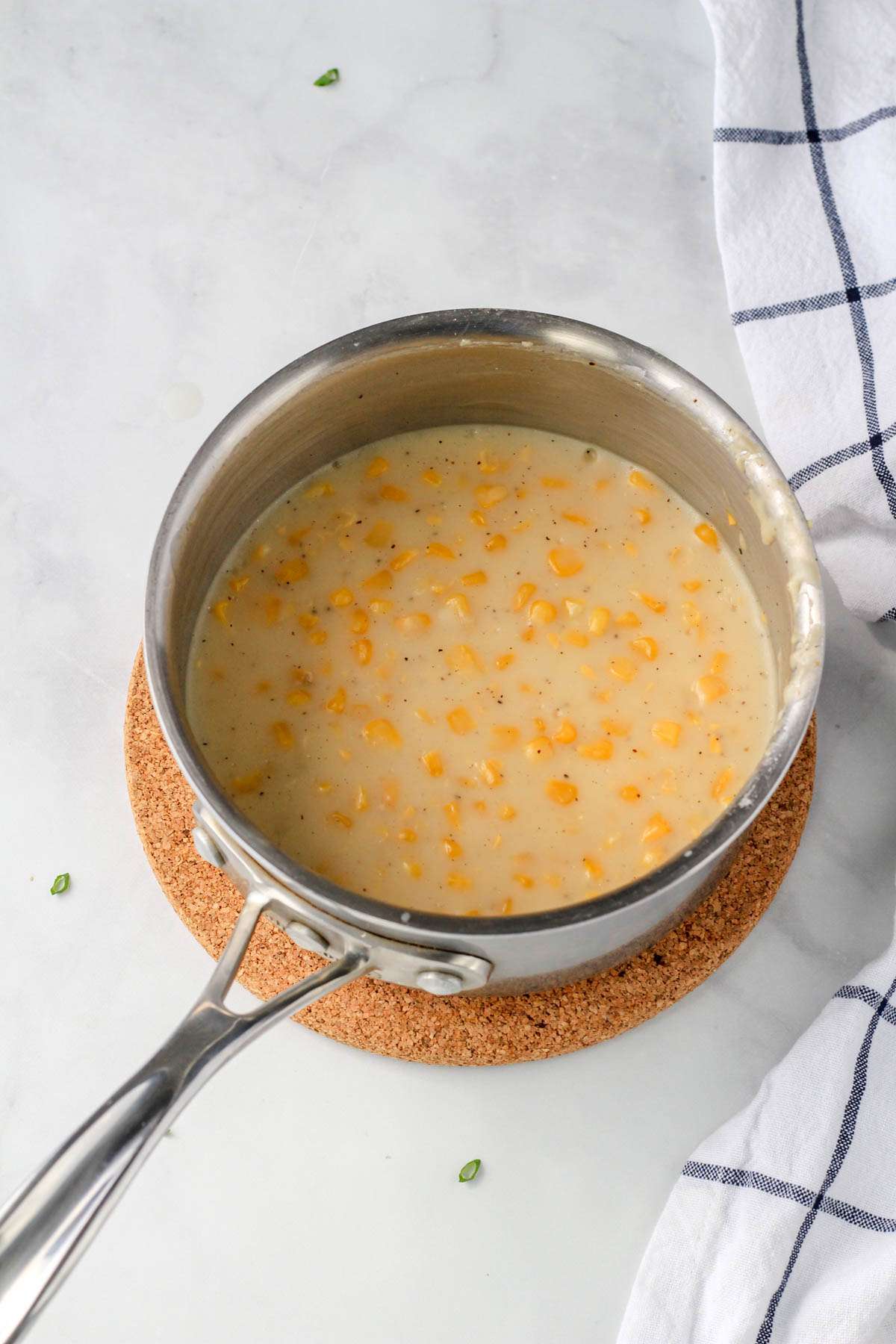 Vegan creamed corn in a sauce pan after reducing the dairy-free milk.