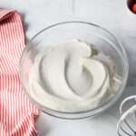 A top down picture of vegan whipping cream in a glass bowl.
