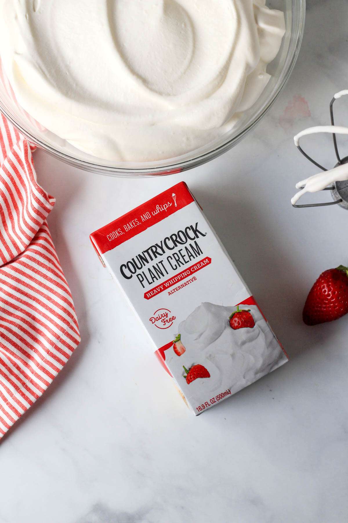 A box of country crock plant cream in front of a glass bowl of vegan whipped cream.