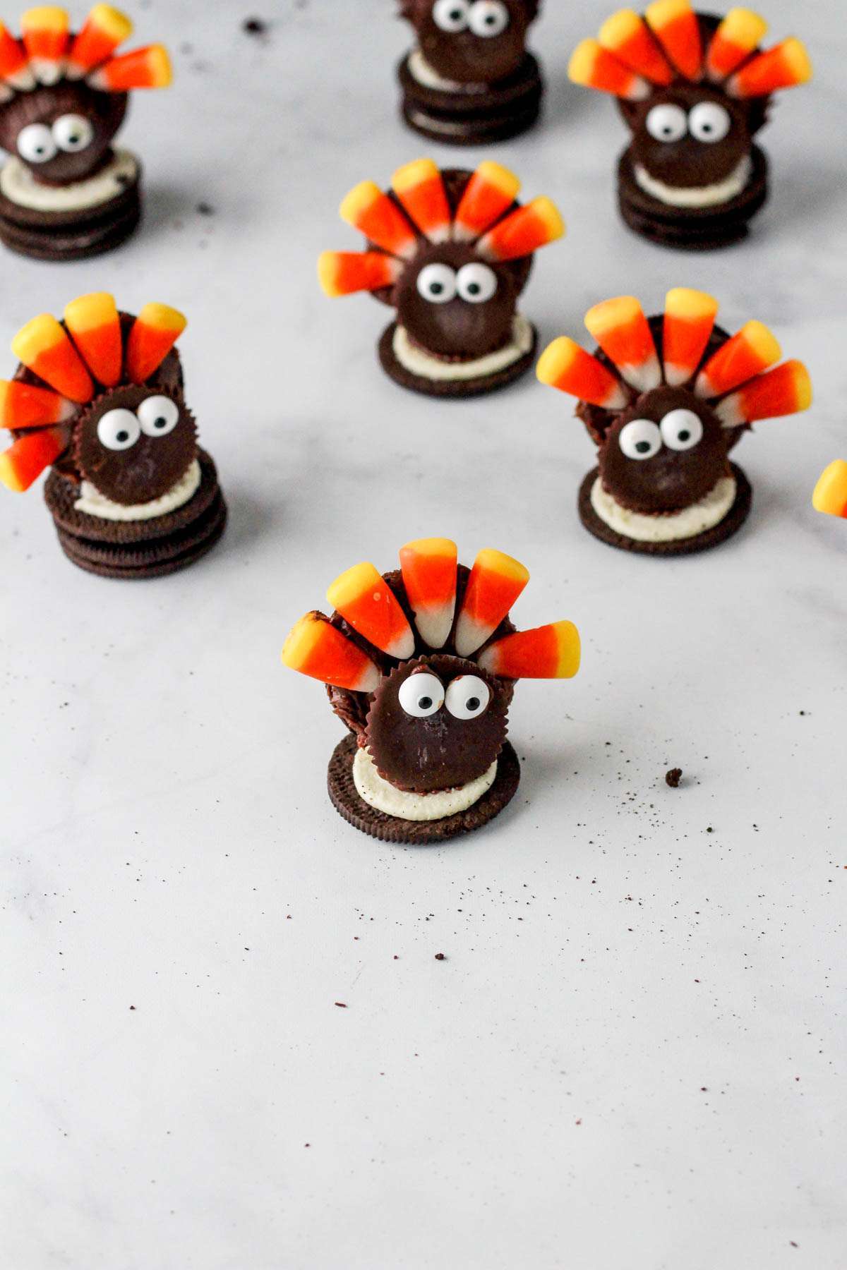 A white counter with dairy-free oreo turkey cookies scattered about.