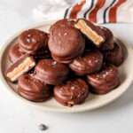 A plate of no-bake vegan chocolate peanut butter Ritz cookies on a white counter.