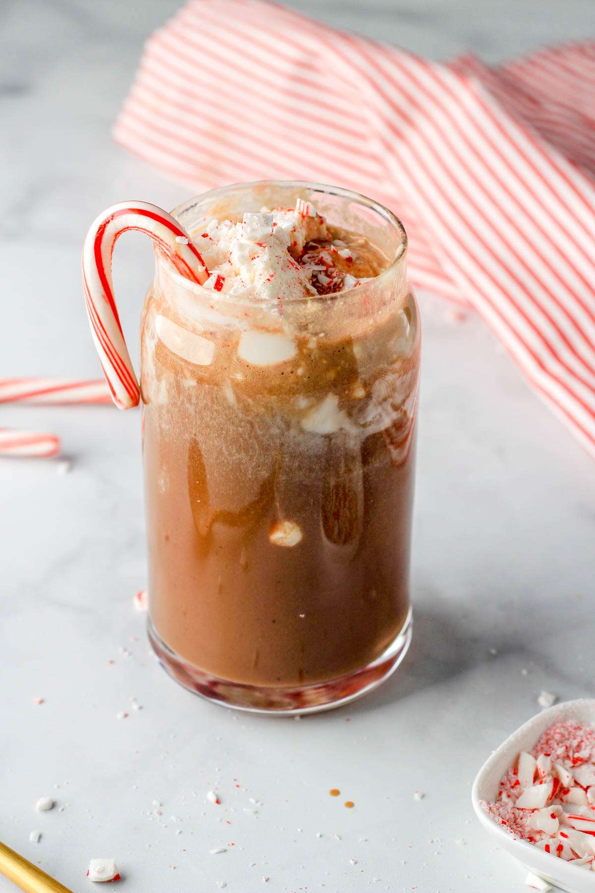 A vegan peppermint mocha latte topped with dairy-free whipped topping and crushed peppermint.