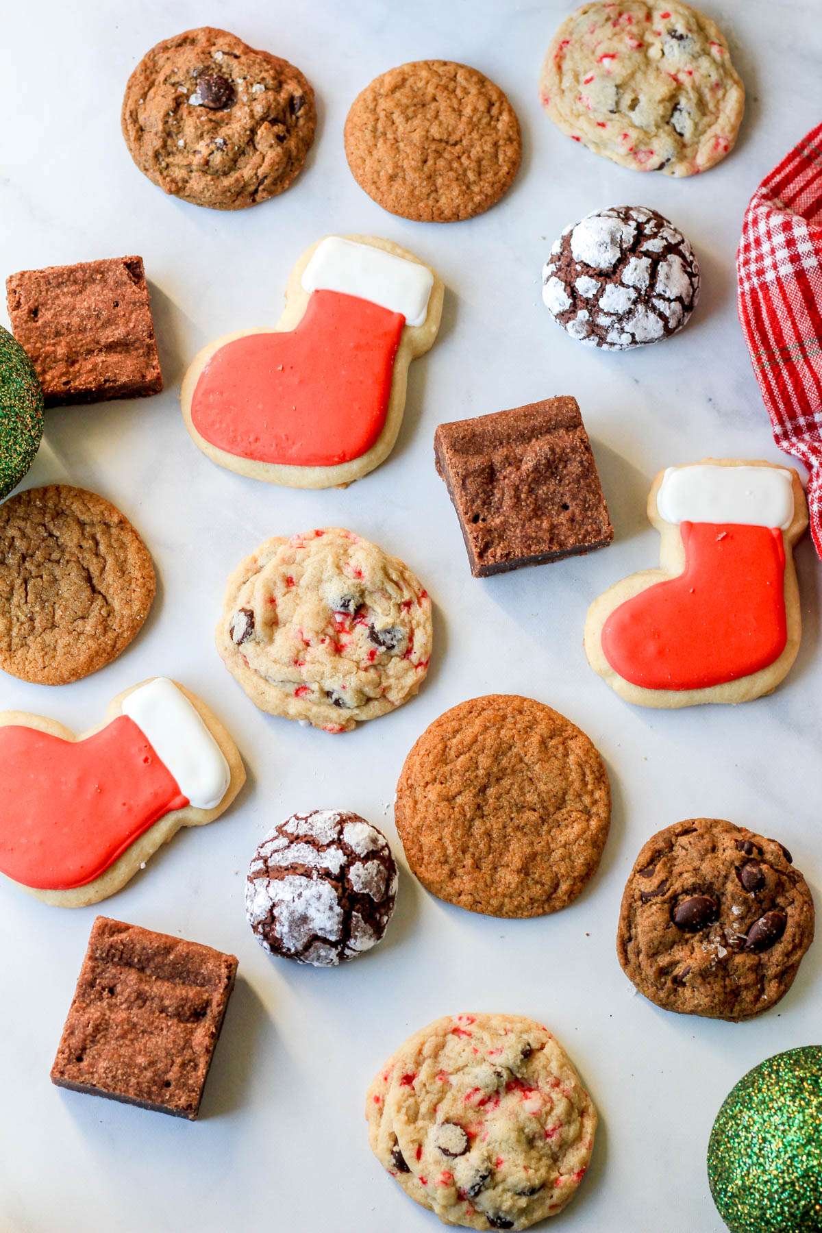 A white counter with different dairy-free holiday cookies scattered about.