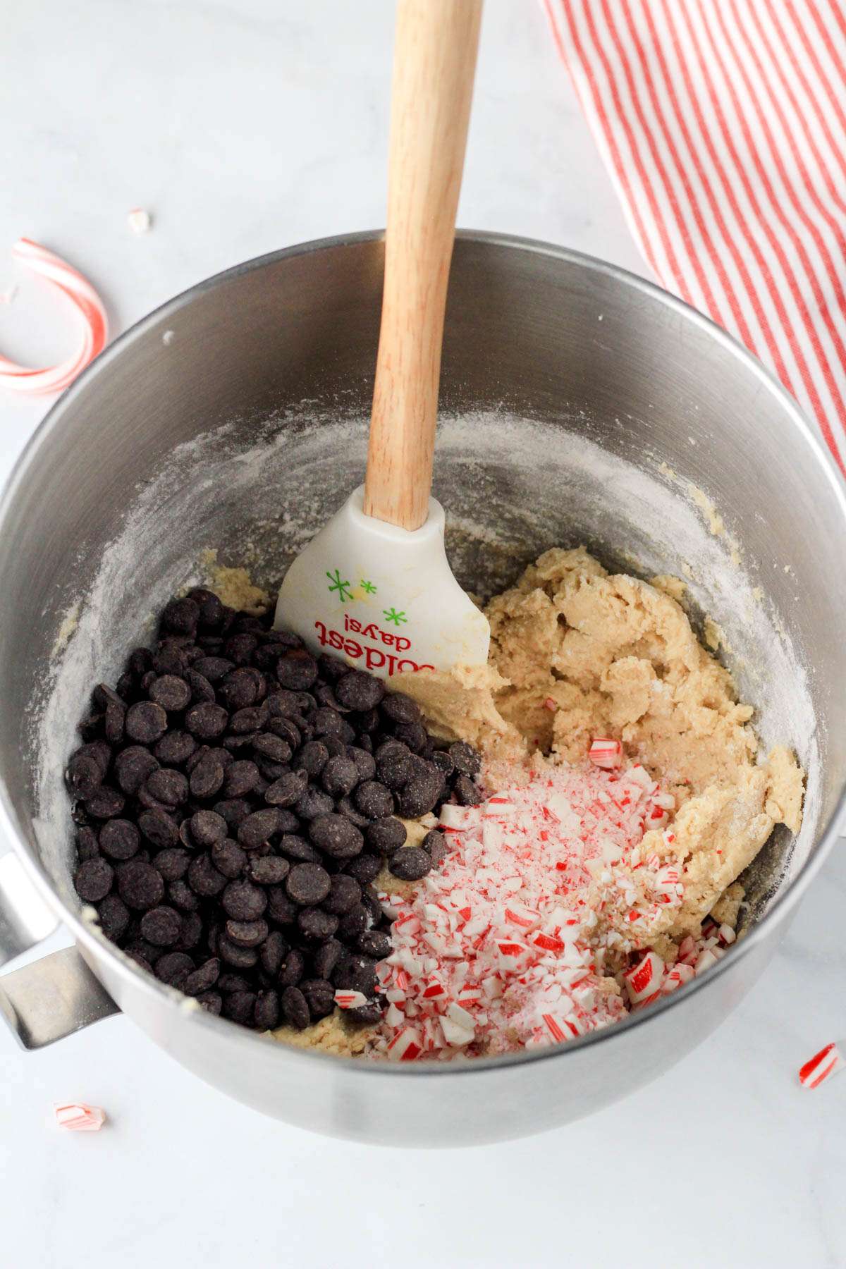 Peppermint chocolate chip cookie dough with crushed candy cane and dark chocolate chips before mixing together.