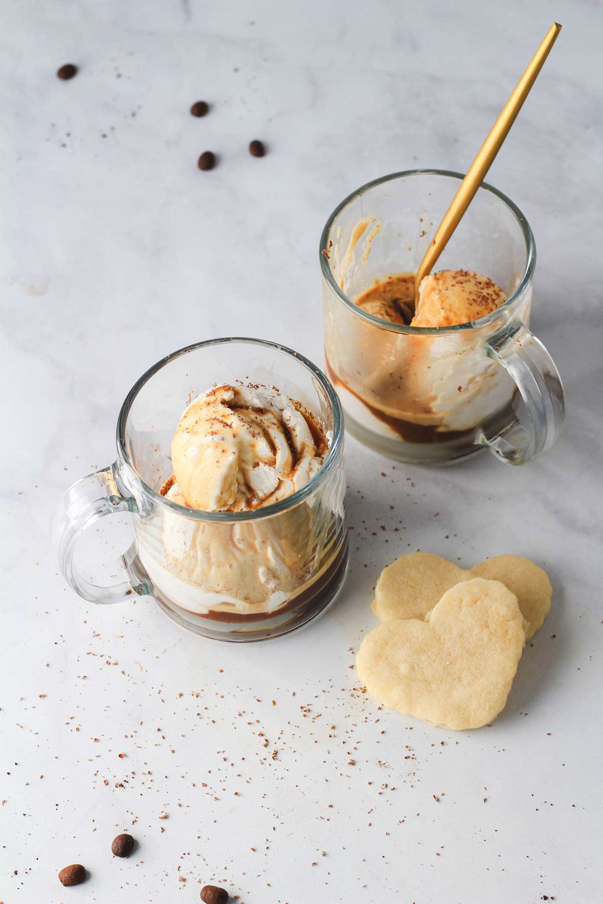 Two vegan affogatos in clear glass mugs with shaved chocolate on top.