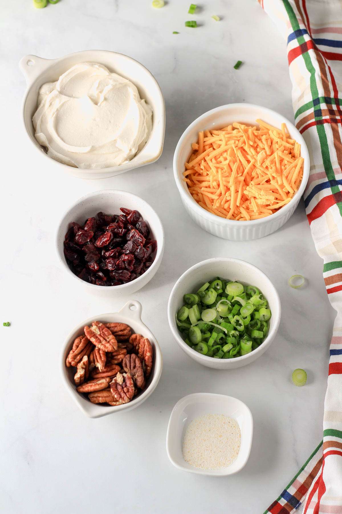 Ingredients for a vegan holiday cheese ball on a white counter.