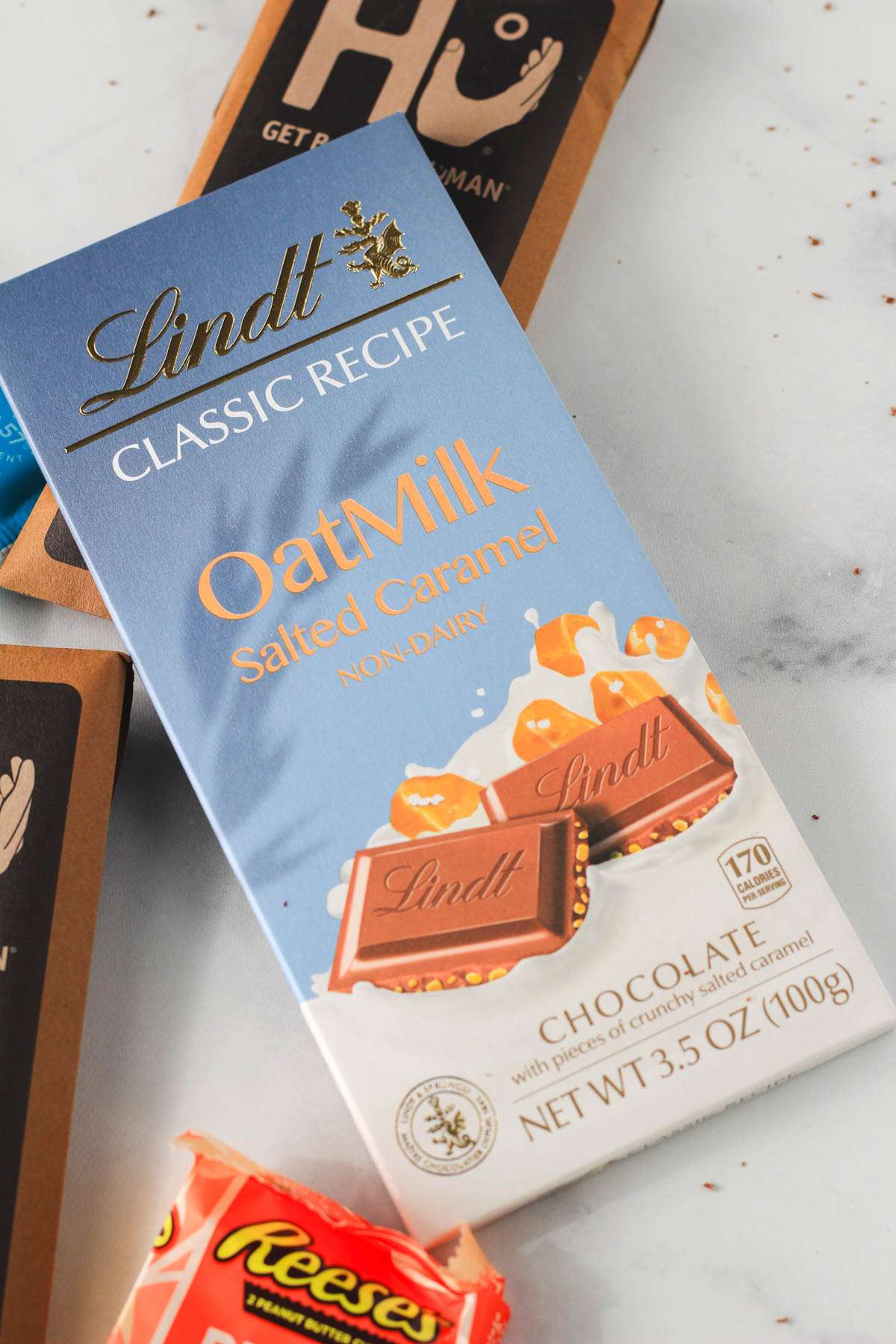 A bar of Lindt Oat Milk chocolate on a white counter.