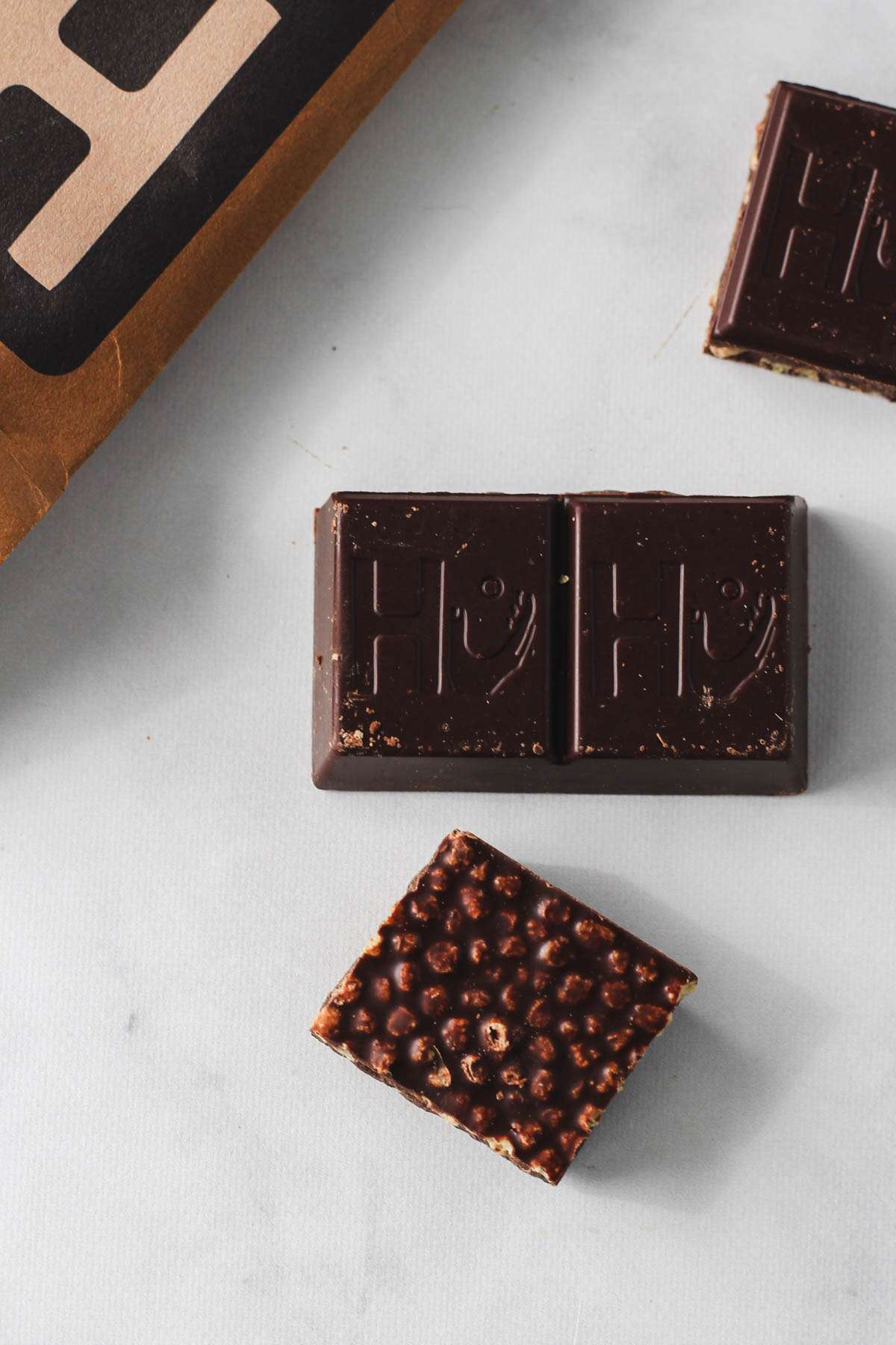 Squares of Vanilla Crunch HU on a white counter.