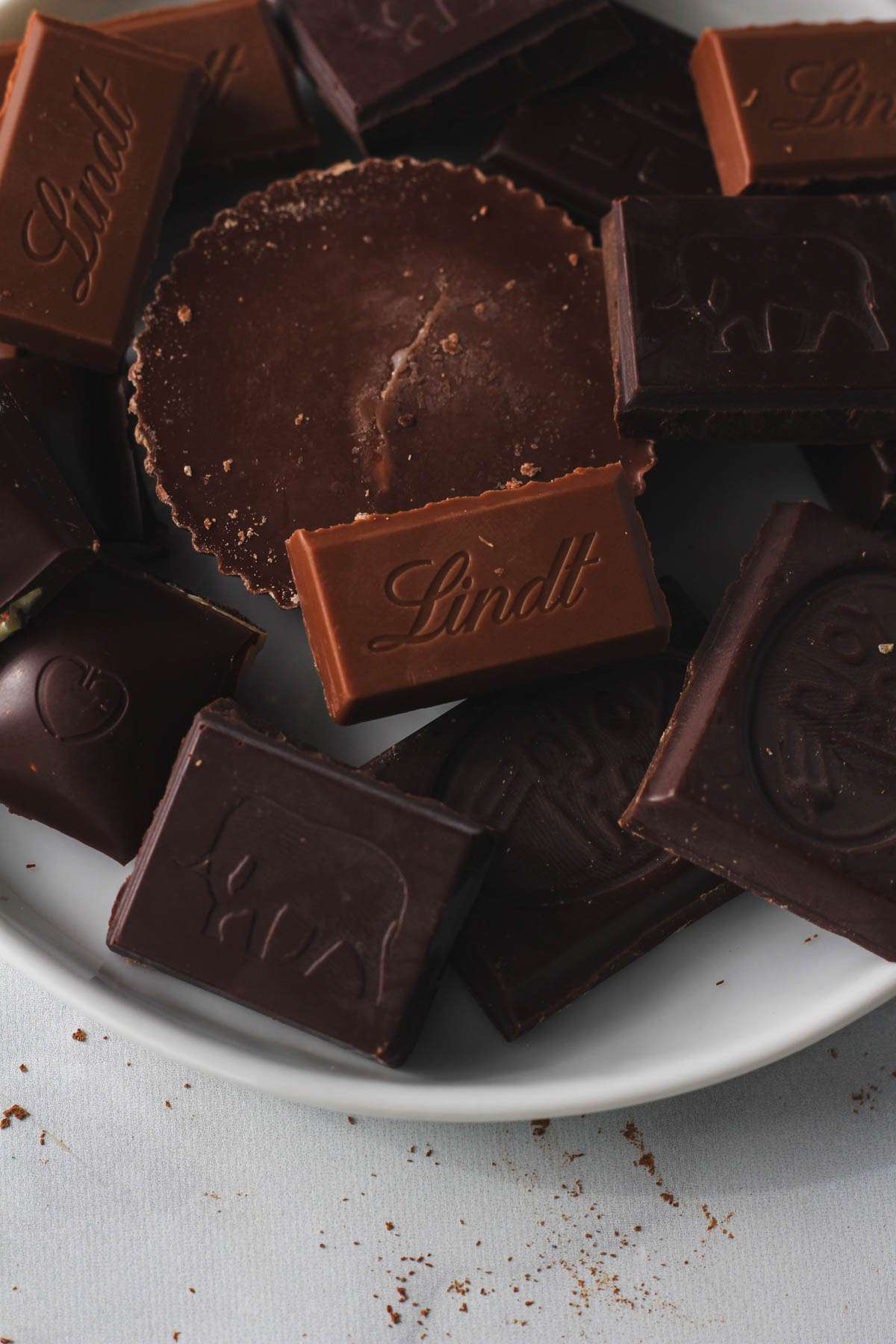 A white plate topped with different pieces of dairy-free chocolate for Valentine's Day.