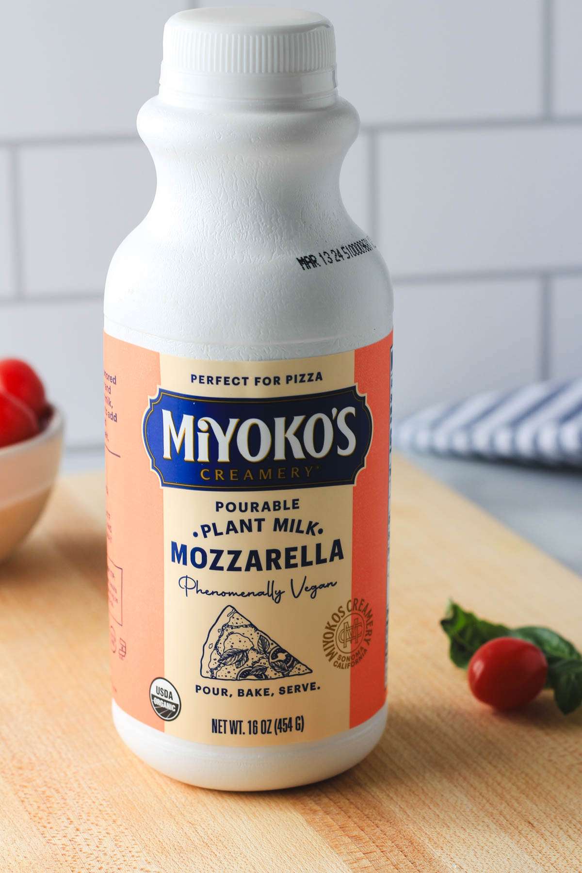 A large white bottle of liquid cheese on a wooden counter.