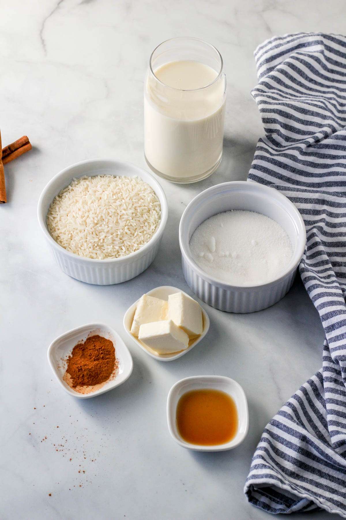 Ingredients for vegan rice pudding on a white counter.