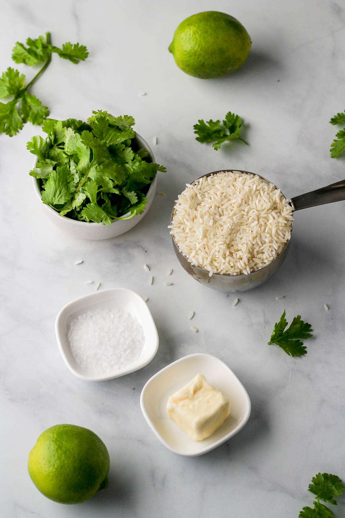 Ingredients for cilantro lime rice on a marble counter.