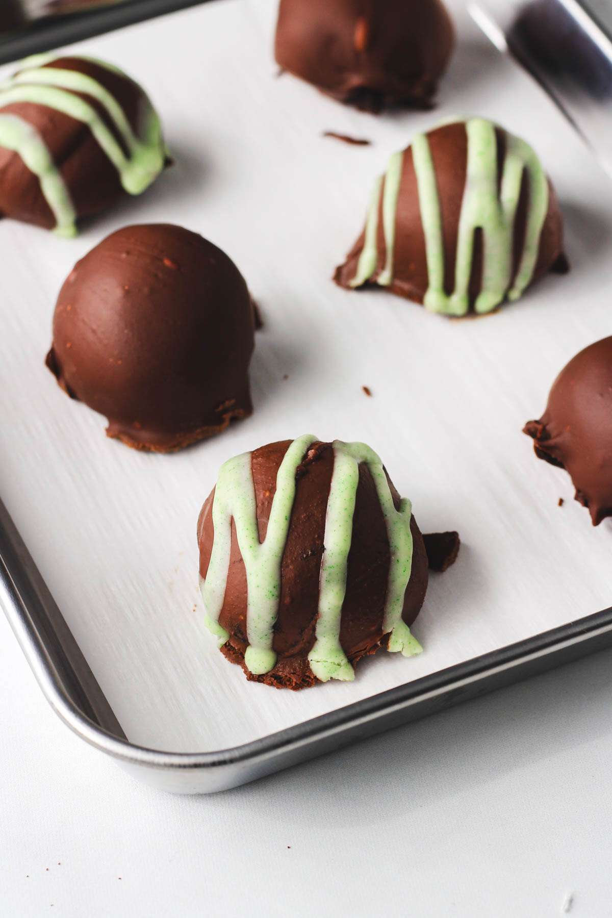 Vegan oreo truffles with Irish cream on a rimmed baking sheet lined with parchment paper.