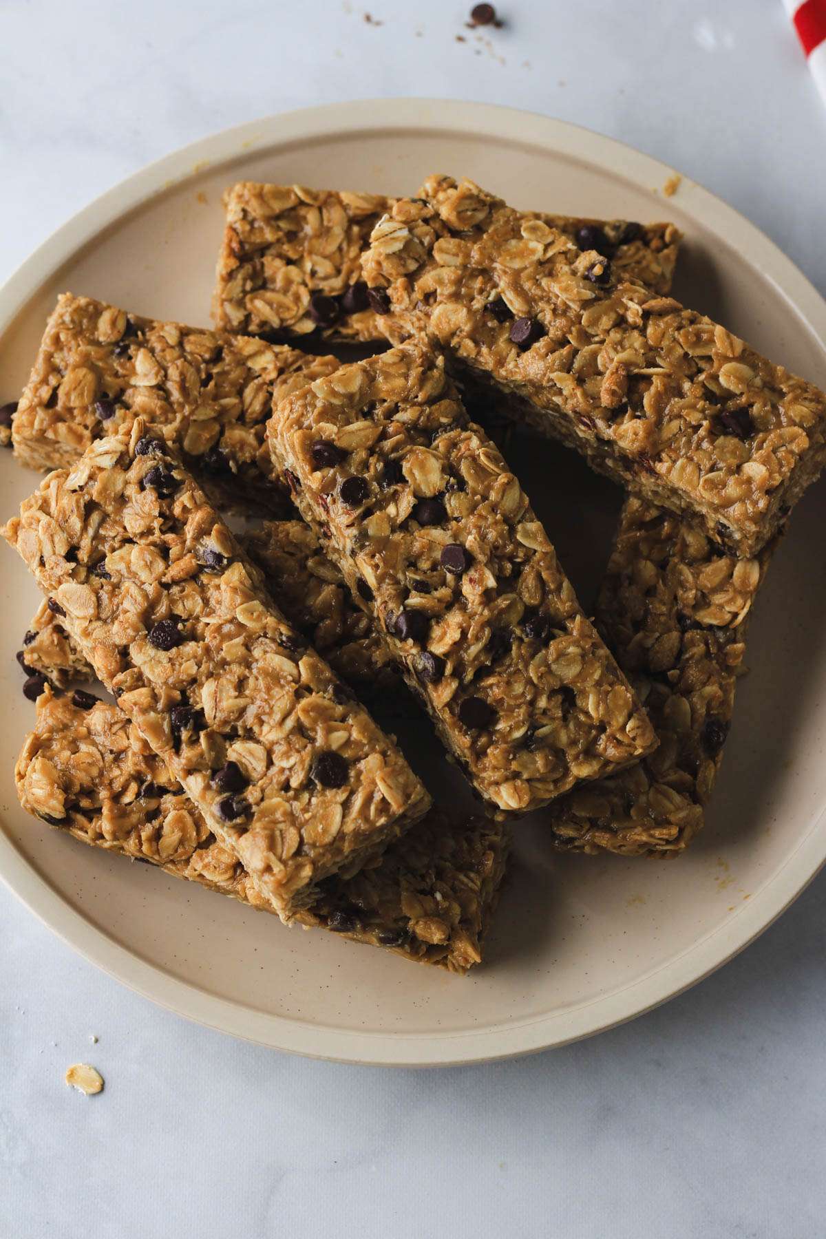 A cream plate topped with homemade nut-free granola bars on a white counter. 