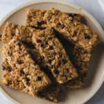 A close up of a cream colored plate with nut-free and dairy-free granola bars.