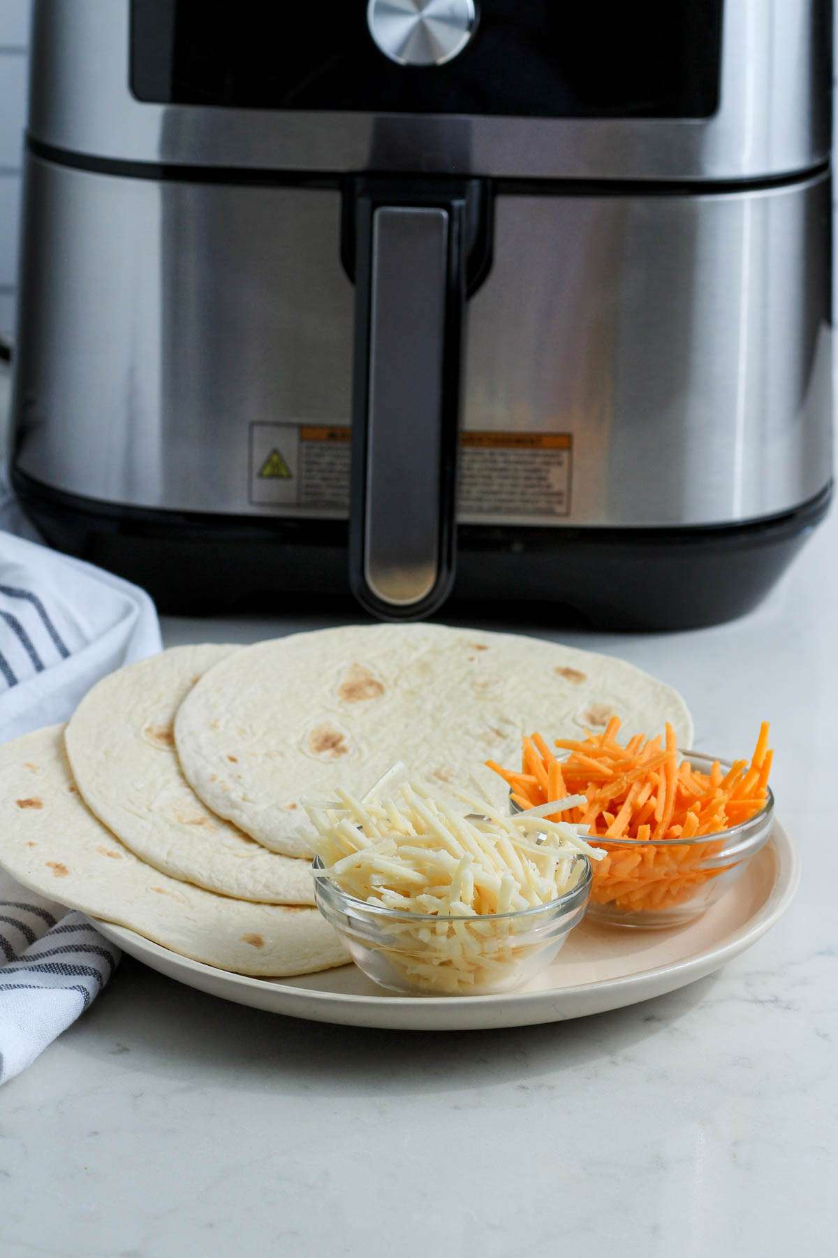Ingredients for air fryer quesadillas on a white counter. 