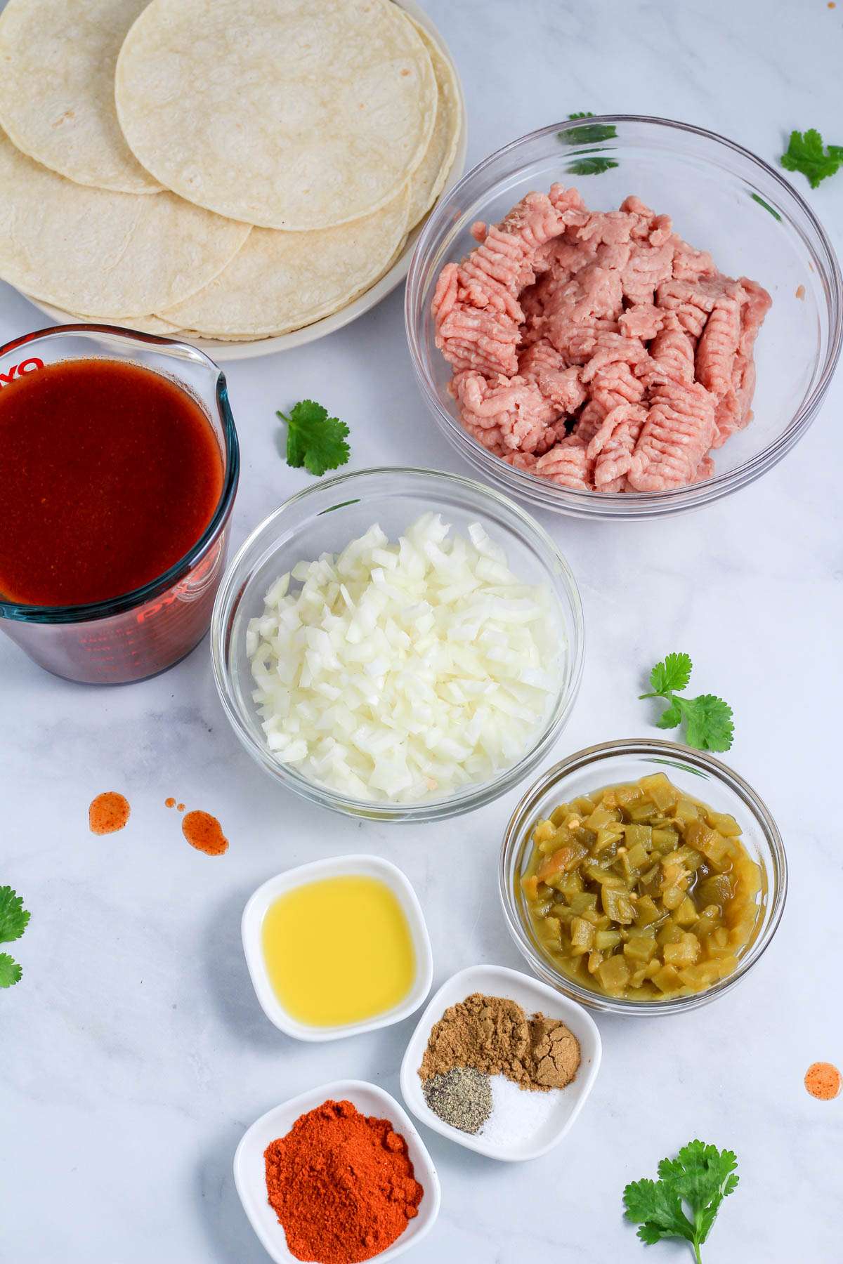 Ingredients for ground turkey enchiladas on a white counter.