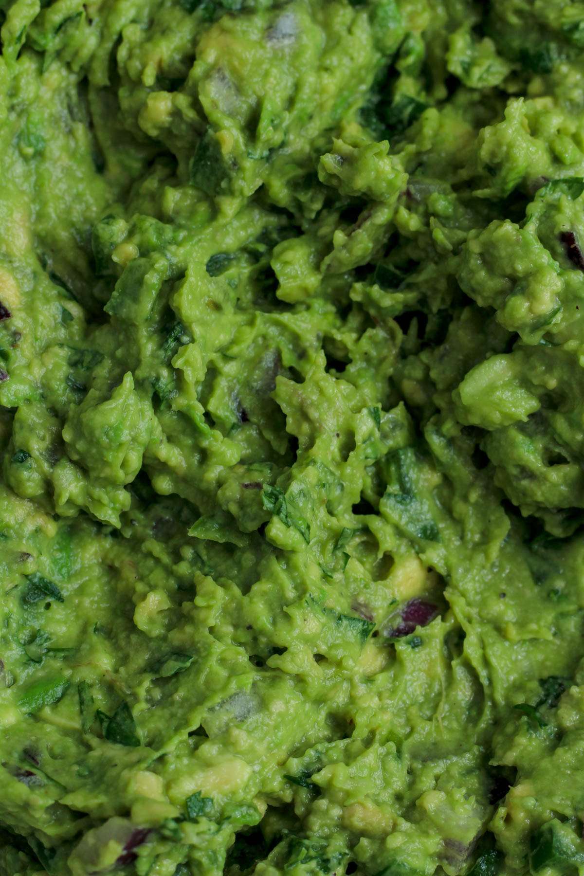 A close up of a swirl of fresh guacamole.