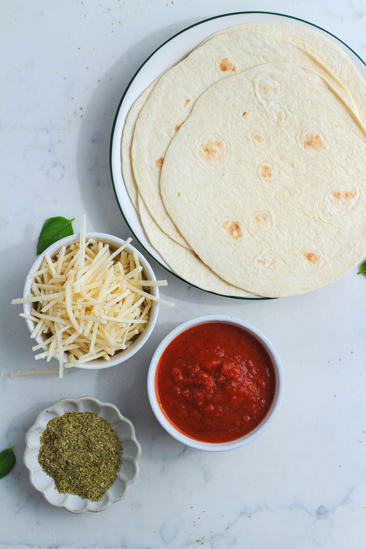 Ingredients for a dairy-free pizza quesadilla on a white counter.