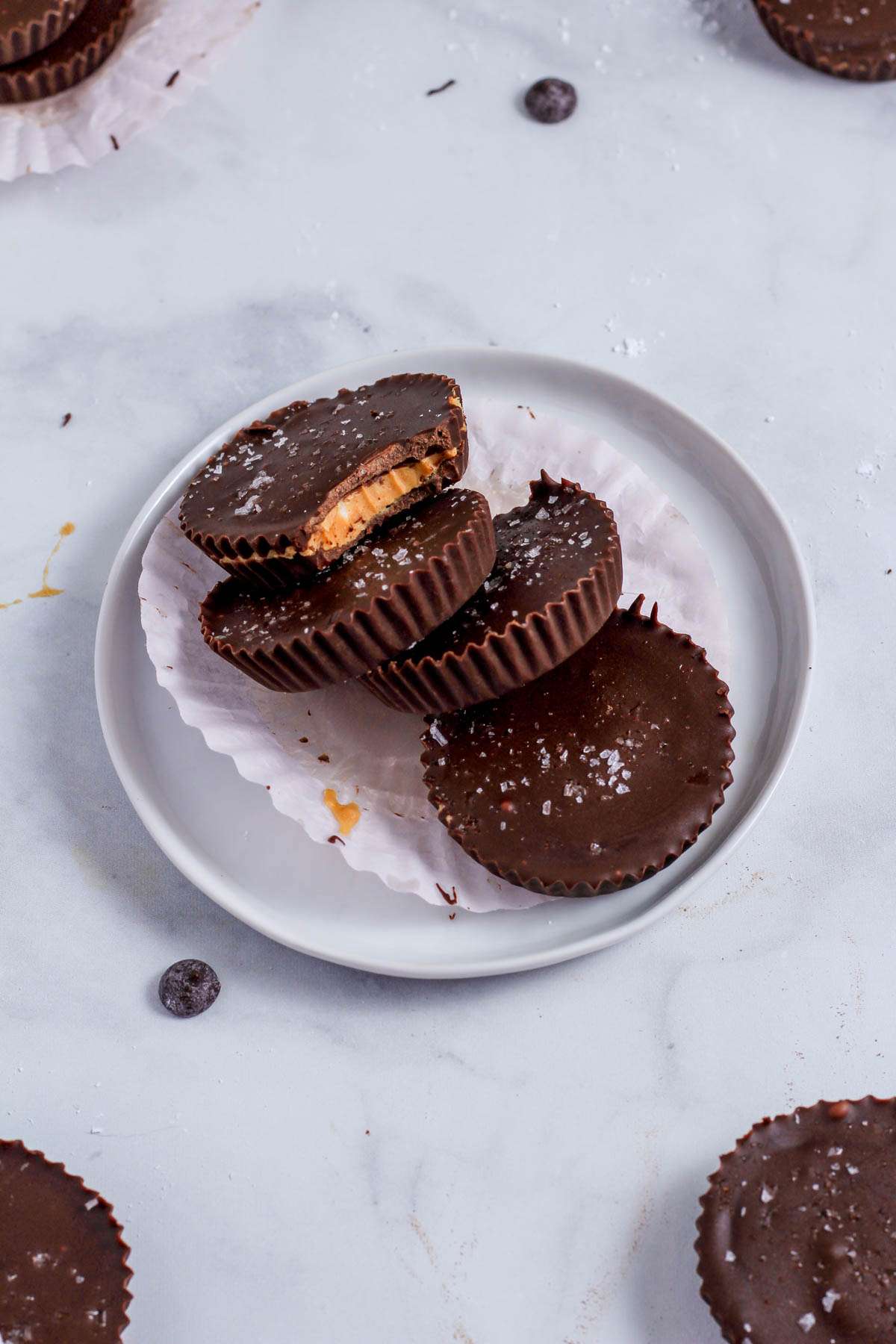A small with plate with a pink cupcake liner and four chocolate peanut butter cups on the plate.