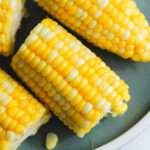 A close up of a section of microwave corn on a green plate.