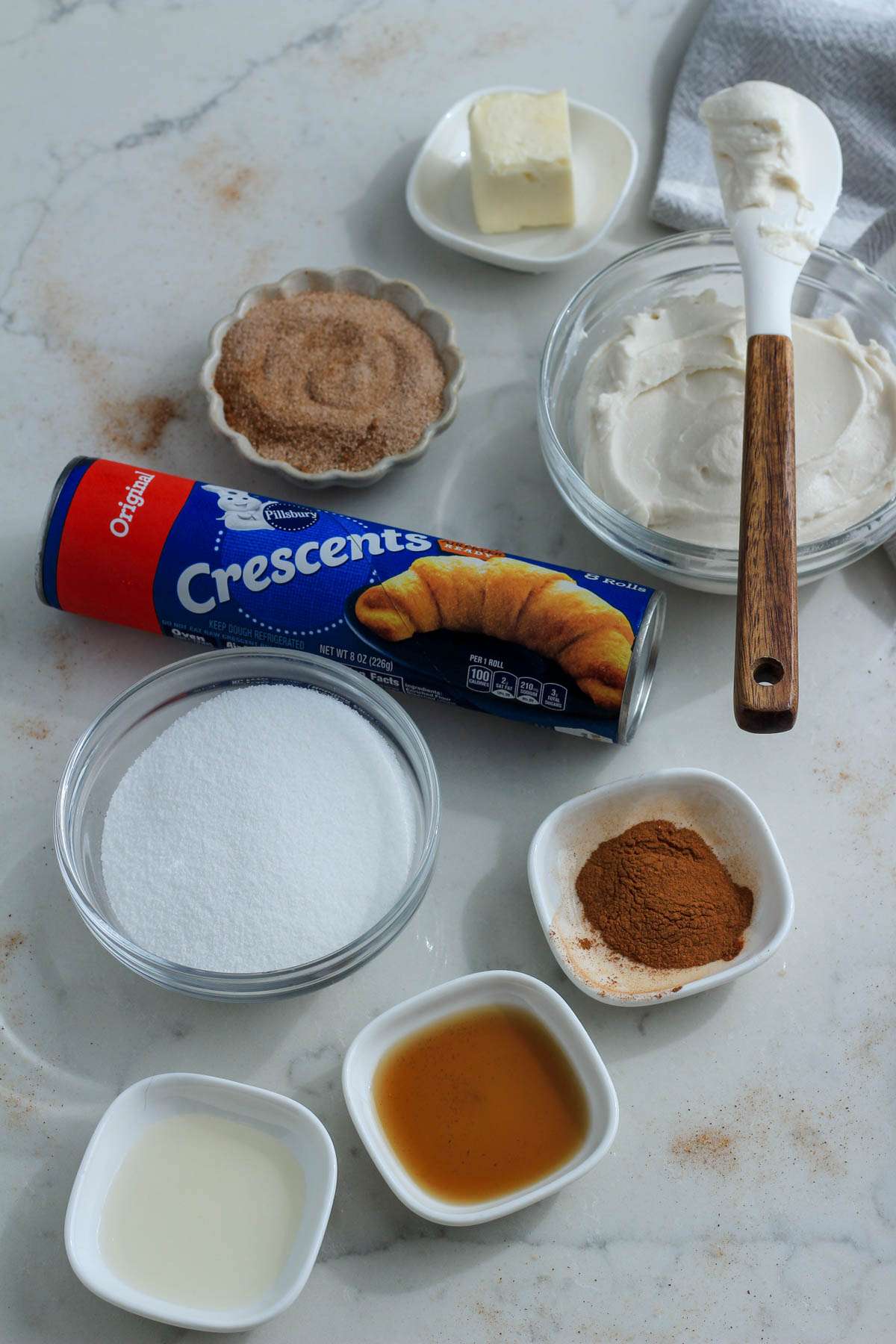 Ingredients for sopapilla cheesecake bars on a white counter.