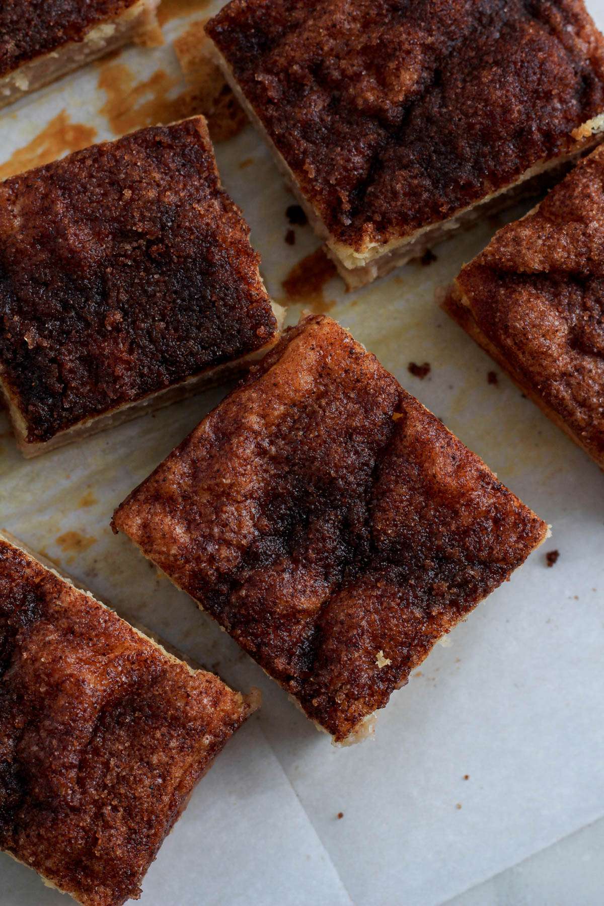 Cut squares of dairy-free sopapilla cheesecake bars on a piece of parchment paper.