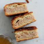 A close up of three dairy-free sopapilla cheesecake bars on a white counter turned to the side showing the filling and layers of the bars.