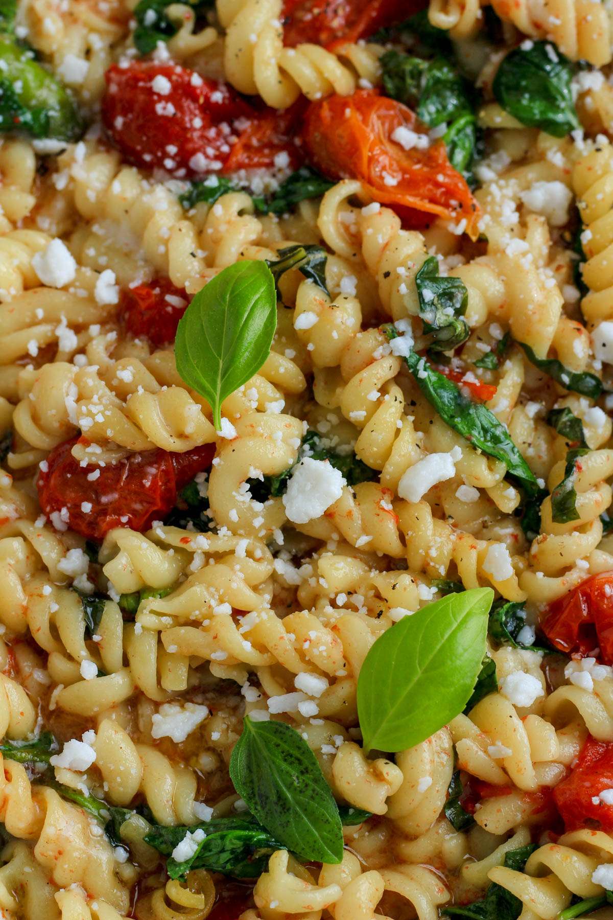 Vegan baked feta pasta topped with fresh basil and additional vegan feta crumbles.