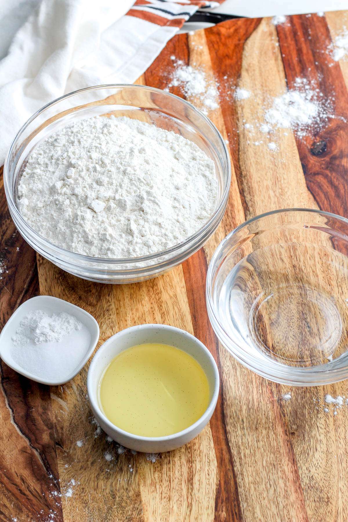 Ingredients for vegan flour tortillas on a wooden counter.