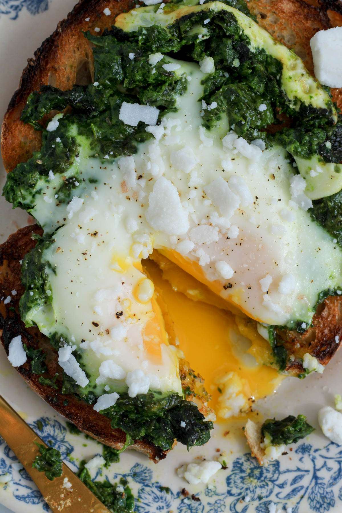 A top down picture of the pesto fried egg toast with a slice cut out and the egg yolk running in the middle.