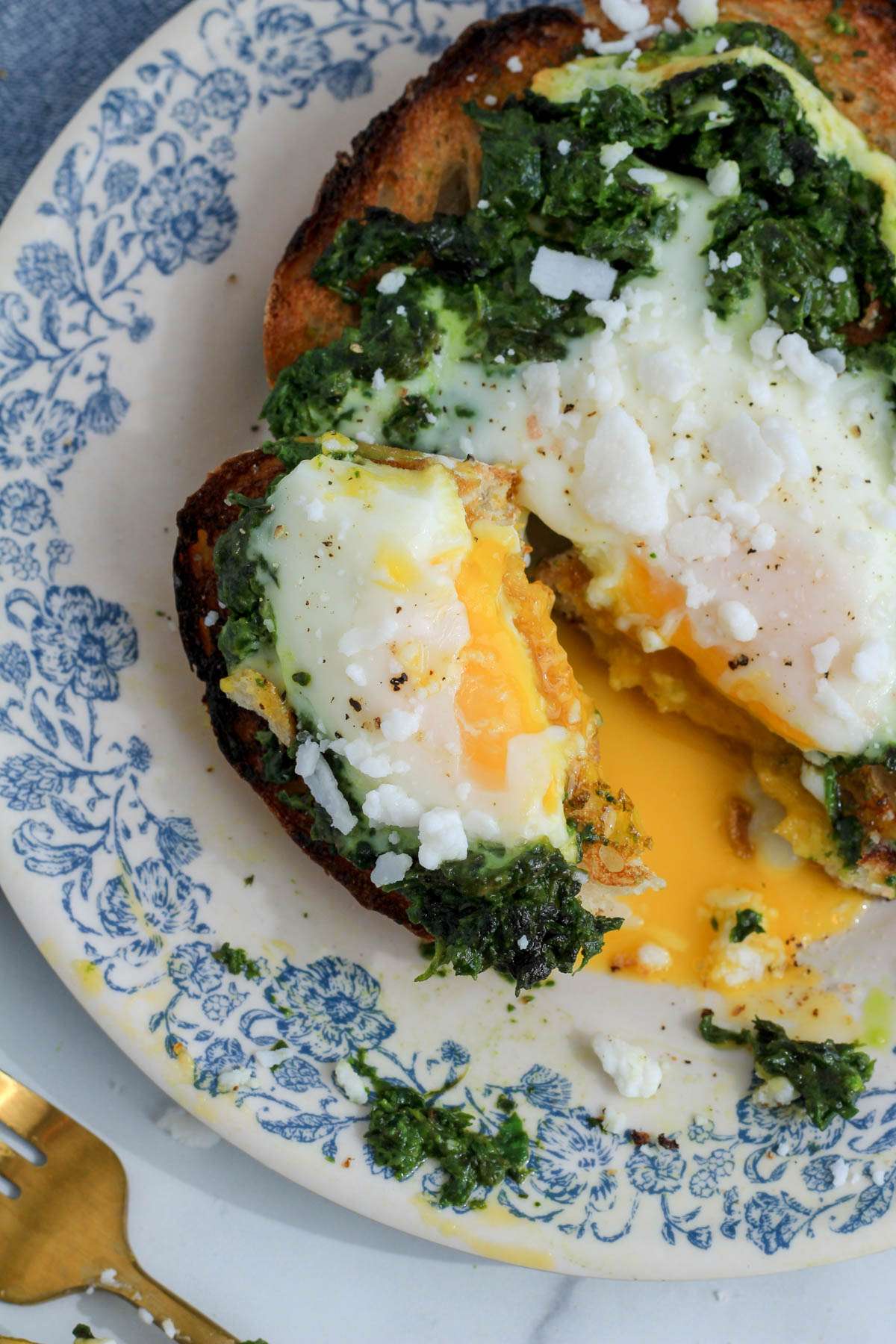 A slice of pesto egg on toast topped to expose the egg yolk partially set.