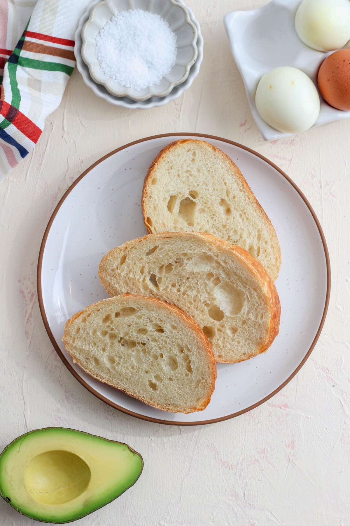 Ingredients for grated egg toast on a cream counter.