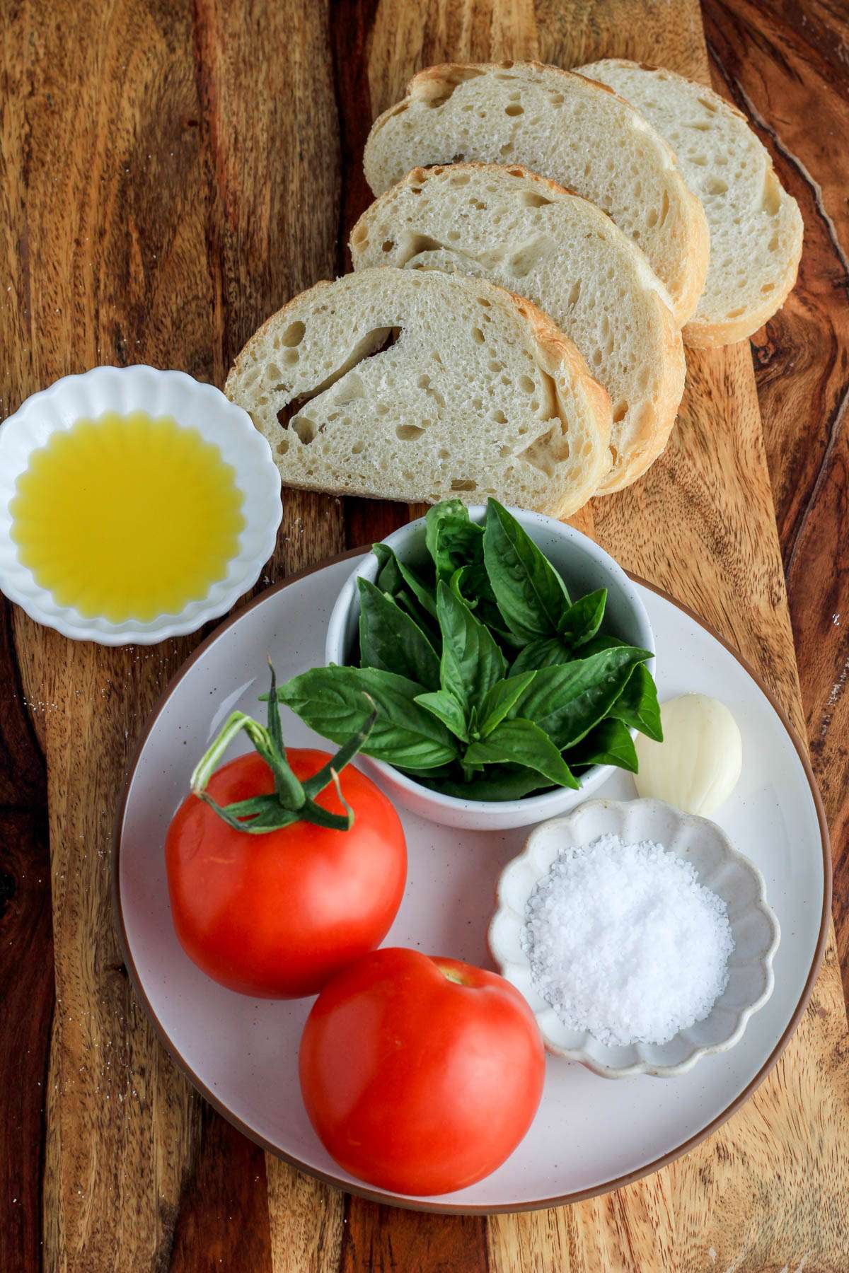 Ingredients for bruschetta toast on a wooden counter.