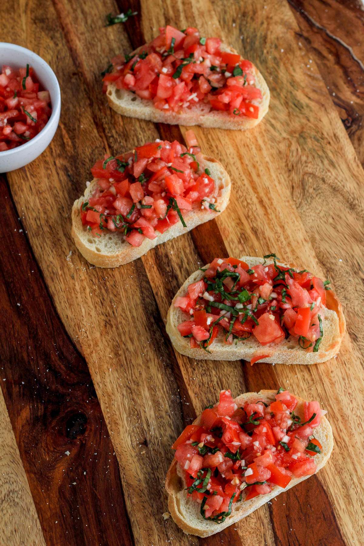 Four pieces of bruschetta on a wooden counter.