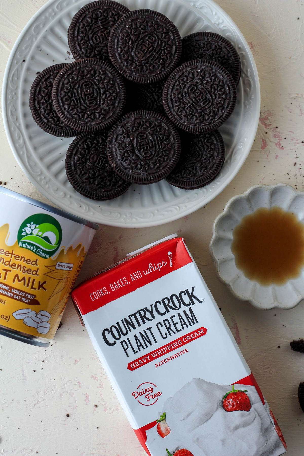 Ingredients for no churn cookies and cream ice cream on a cream counter.
