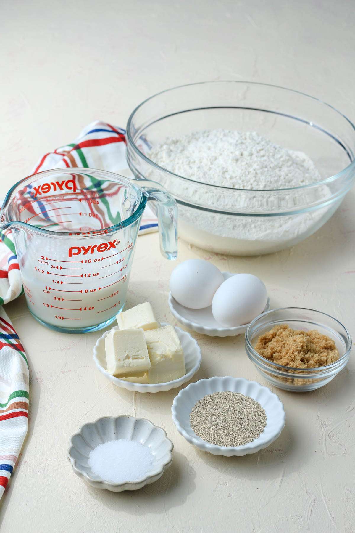 Ingredients for cinnamon roll dough on a cream counter.