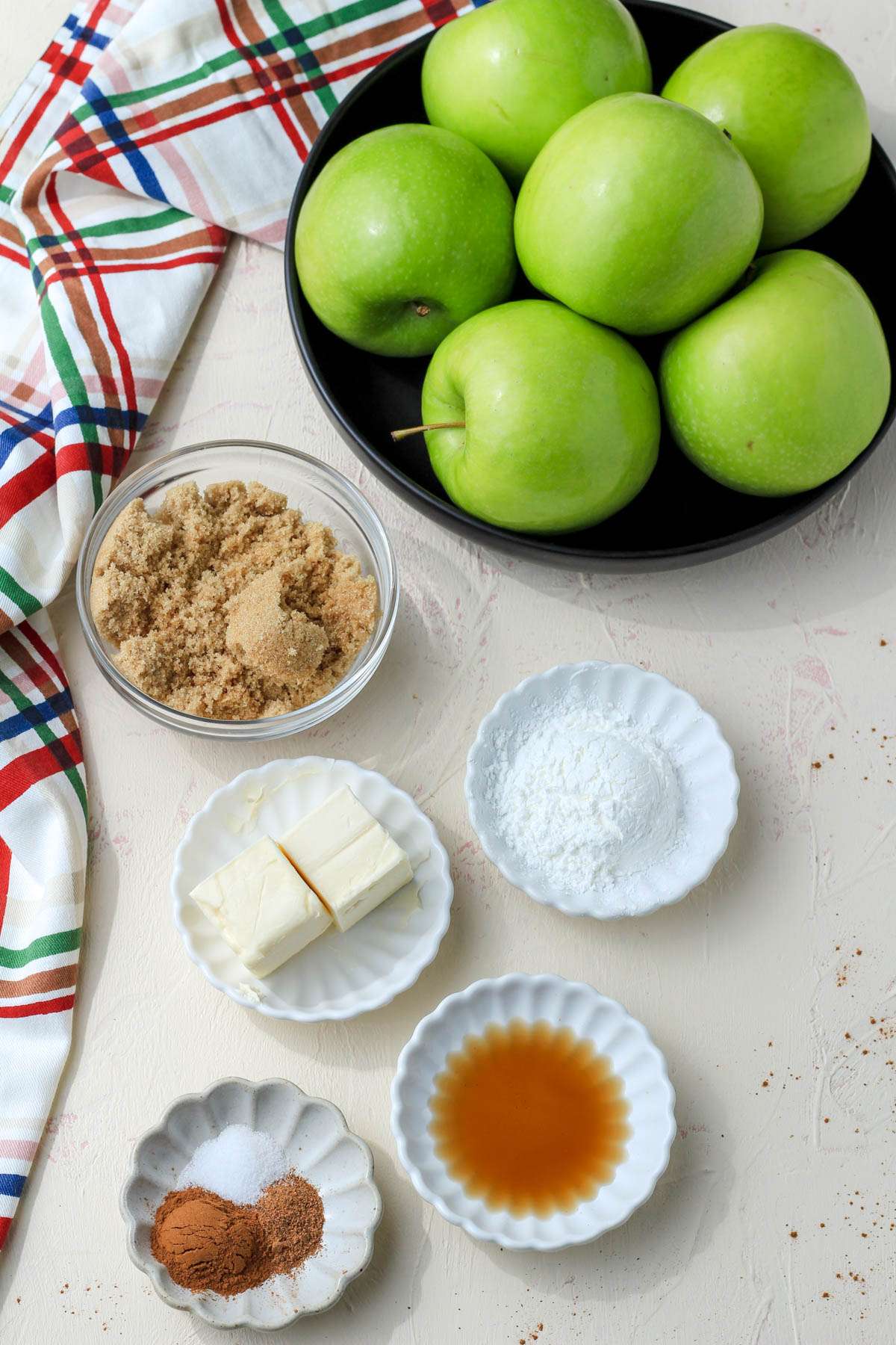 Apple pie filling ingredients on a cream counter.