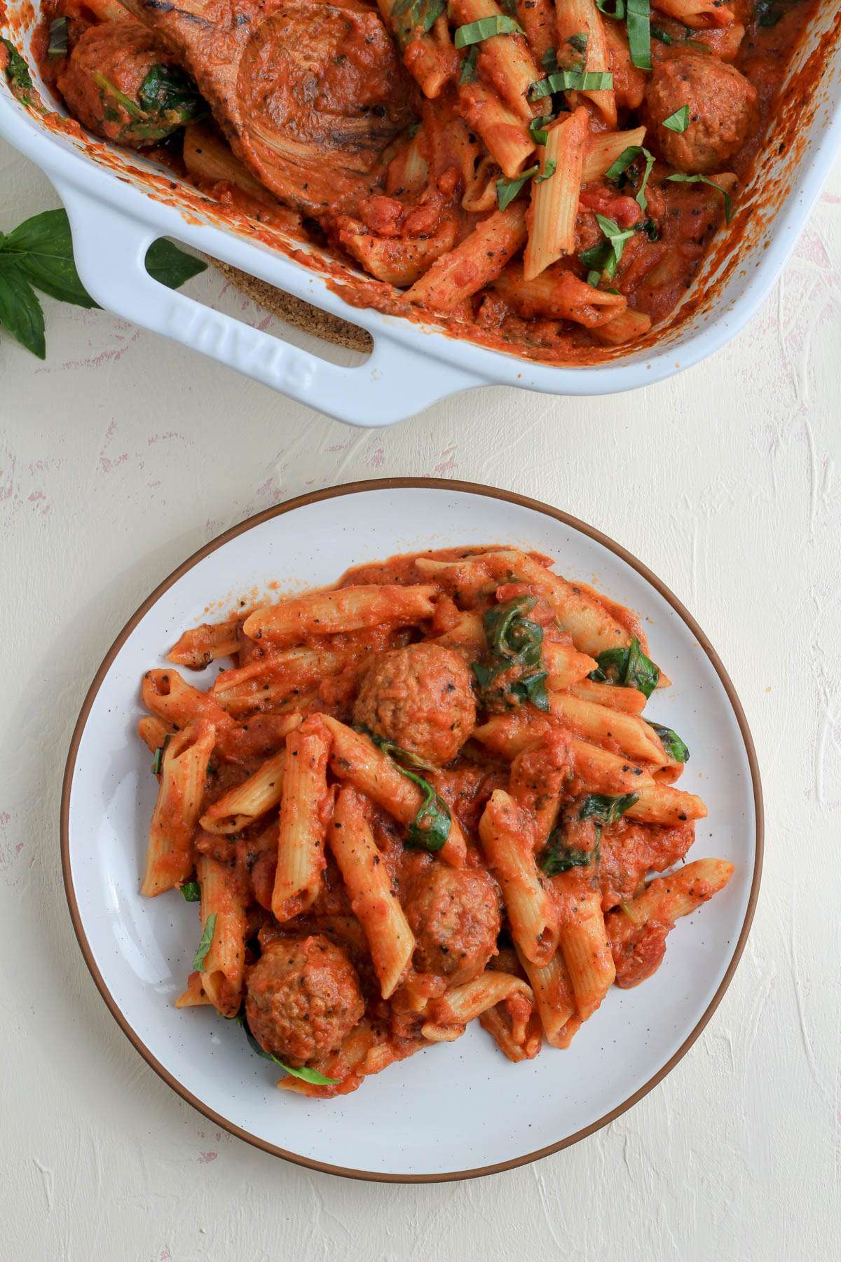 A white plate with a brown rim topped with a serving of dairy free baked penne.