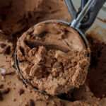 A close up of an ice cream scoop with vegan no churn chocolate chocolate chip ice cream.