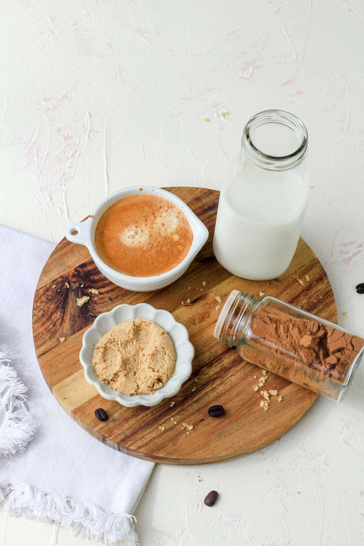 Ingredients for a brown sugar oat milk shaken espresso on a wooden circle.