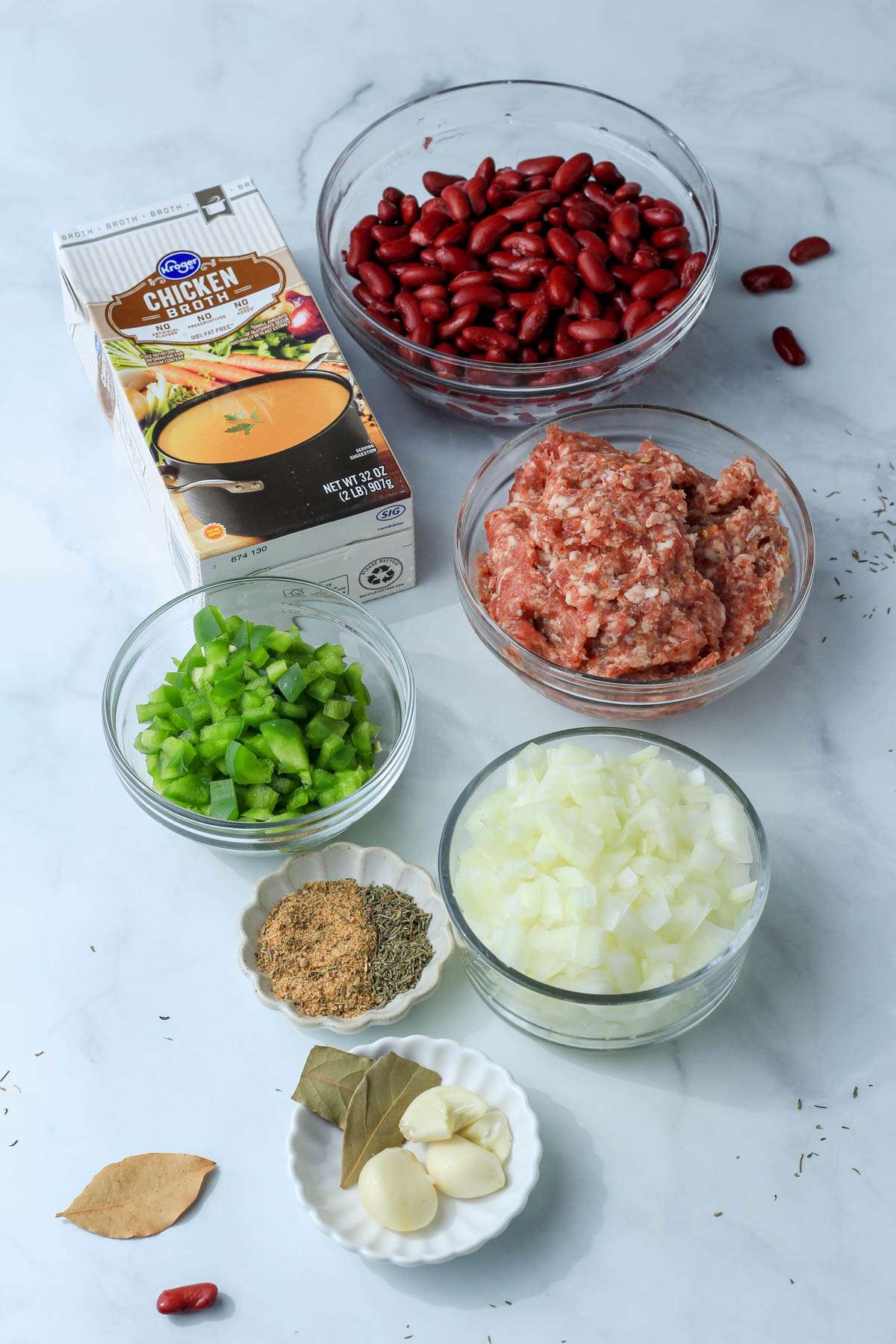 Ingredients for red beans and rice on a white counter.
