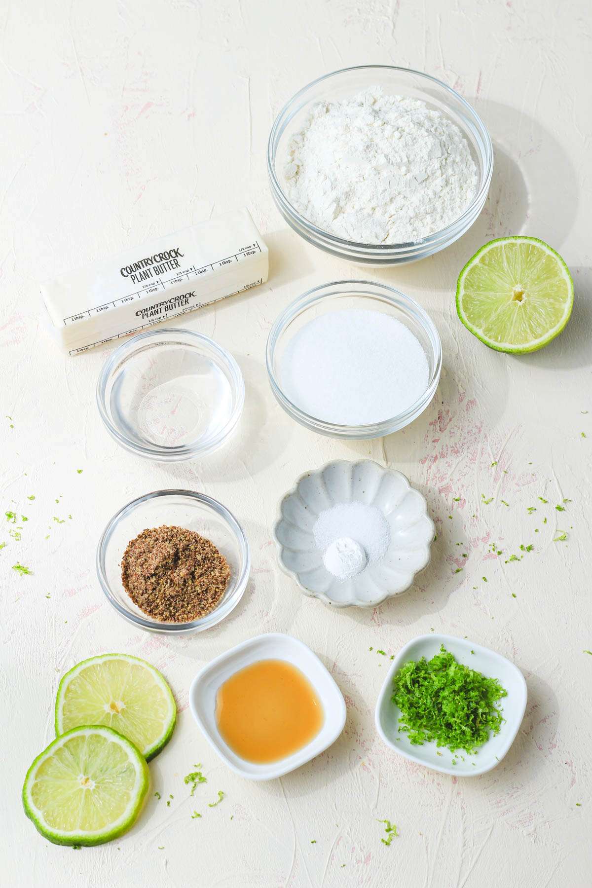 Ingredients for soft vegan lime cookies on a cream counter.