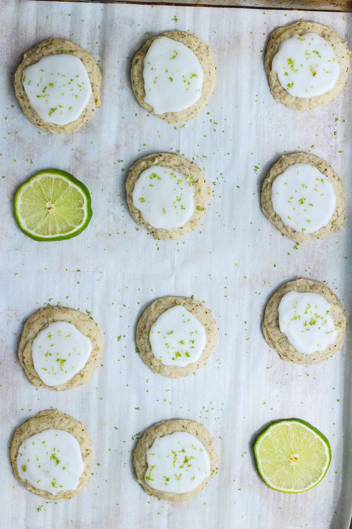 A top down picture of soft vegan lime cookies iced and topped with lime zest.