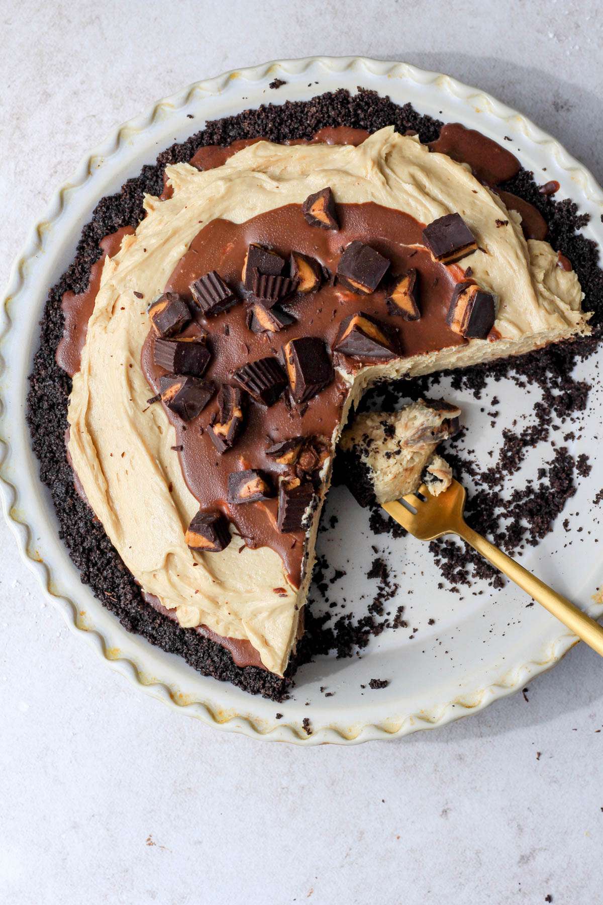 A top down picture of Oreo peanut butter pie with a gold fork and a bite of pie on the fork.