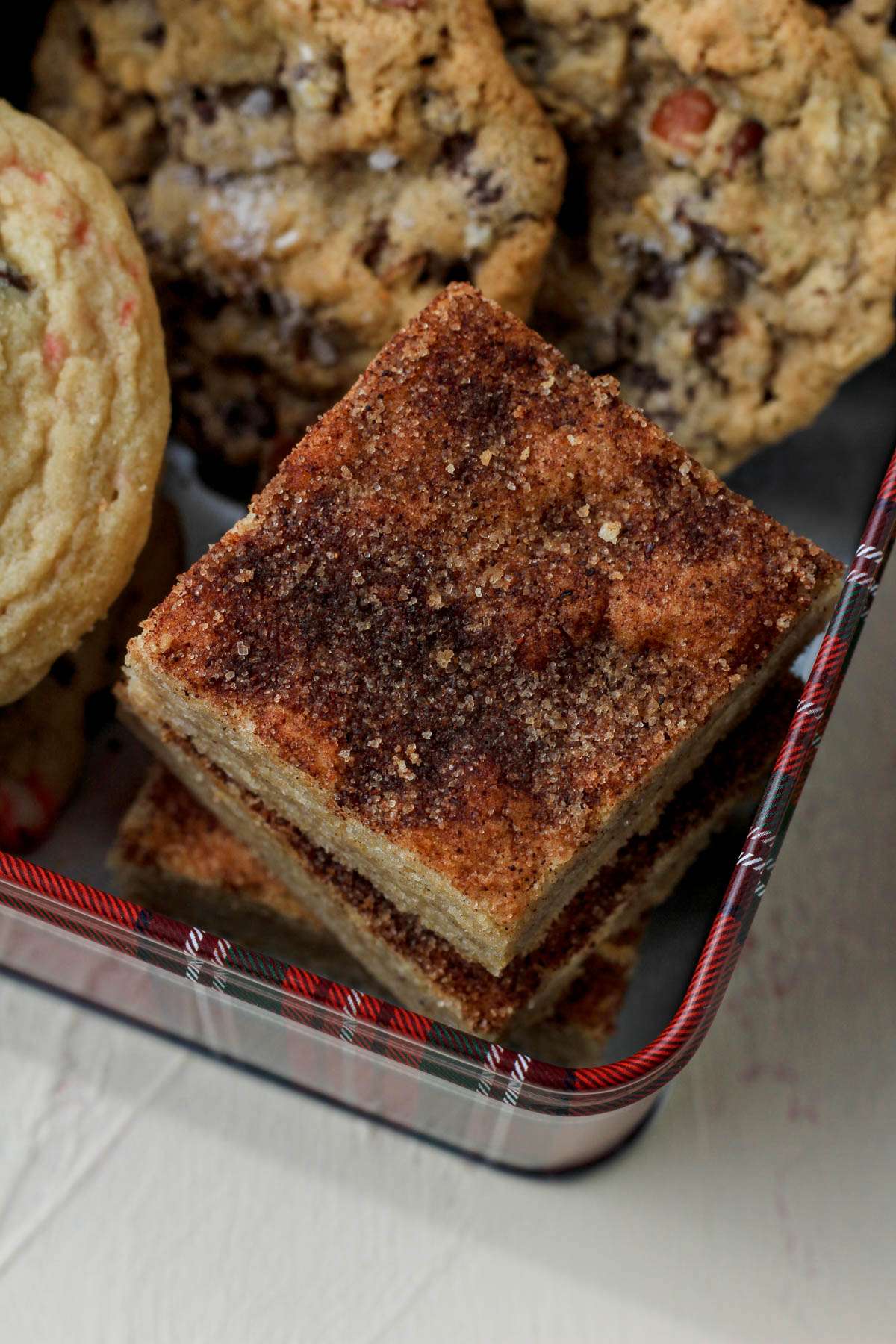 A close up of snickerdoodle cookie bars in a red and white christmas tin.