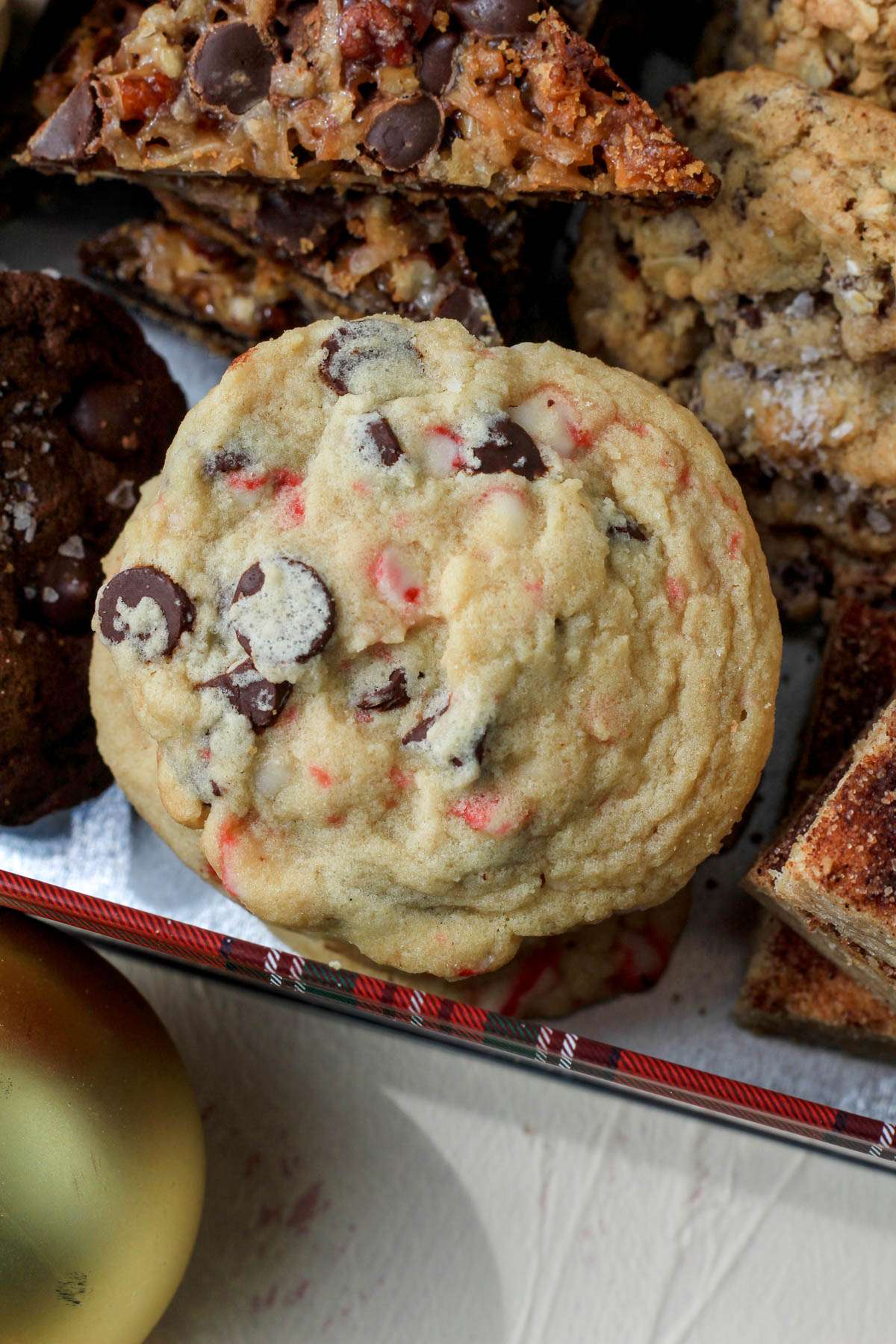 A close up of peppermint chocolate chip cookies in a red and green tin.